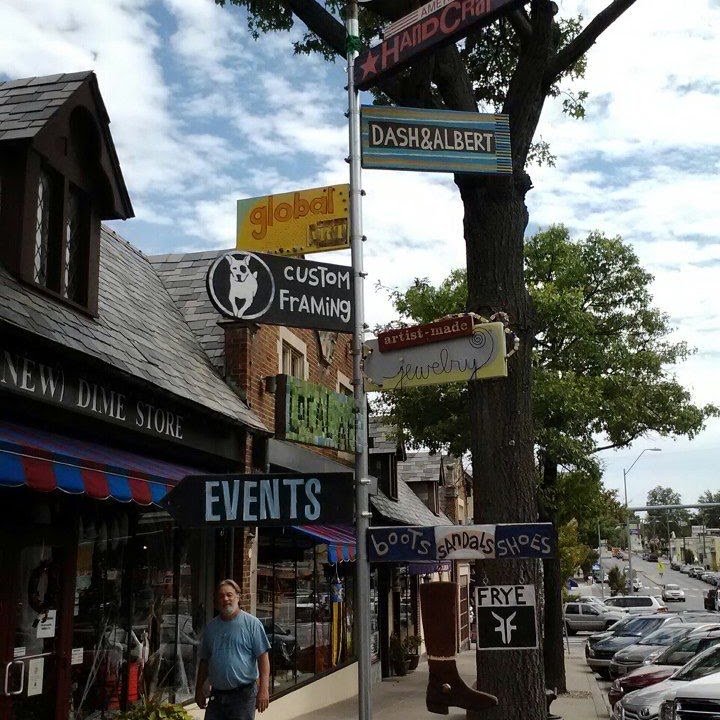 A row of independent shopfronts on a Kansas City street, awnings out.